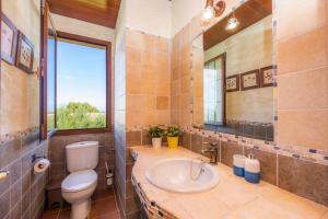 a bathroom with a toilet and a sink and a window at Estrella in Son Serra de Marina +20 photos