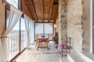 a room with a table and chairs and windows at Casa el Arroyal in Rades de Abajo