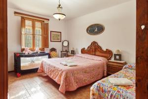 a bedroom with two beds and a baby in a crib at Cortijo Rural Majolero 3 in Castillo de Locubín
