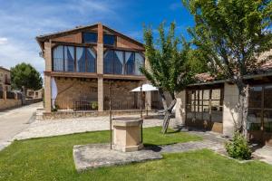 a house with an umbrella in front of it at Casa el Arroyal in Rades de Abajo