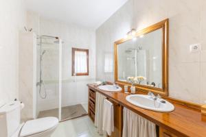 a bathroom with two sinks and a shower and a mirror at Casa el Arroyal in Rades de Abajo +34 photos