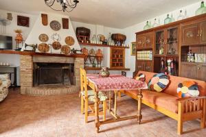 a living room with a couch and a table and a fireplace at Cortijo Rural Majolero 3 in Castillo de Locubín