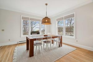 a dining room with a table and chairs and windows at 3 Mins to York Beach Large Deck Water View in York