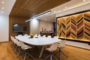a conference room with a white table and chairs at Diez Hotel Categoría Colombia in Medellín