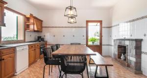 a kitchen with a table and chairs and a fireplace at Villa Hort de Can Rafalet in Ses Salines