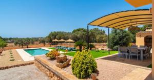 a villa with a pool and a table and chairs at Villa Hort de Can Rafalet in Ses Salines