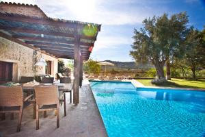 a patio with a table and chairs next to a swimming pool at Villa Can Rafal Ibiza in Sant Josep de sa Talaia
