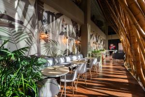 a restaurant with tables and chairs and plants at Diez Hotel Categoría Colombia in Medellín