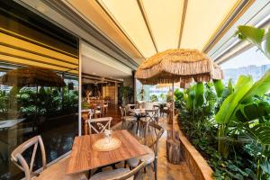 a restaurant with tables and chairs and plants at Diez Hotel Categoría Colombia in Medellín