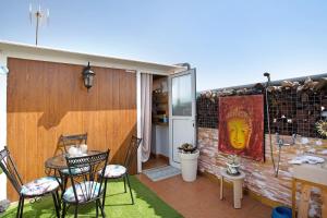 a patio with chairs and a table and a painting at Casa Siryo in Castillo del Romeral