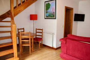 a living room with a table and a red couch at Solar de Rabal in Bragança