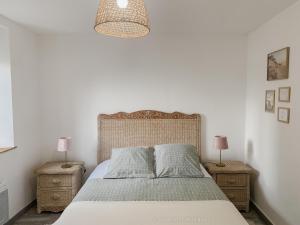 a bedroom with a bed with two night stands and two lamps at Gîte bord de mer - le Chardon in Pirou