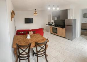 a kitchen and dining room with a wooden table and chairs at Gîte bord de mer - le Chardon in Pirou