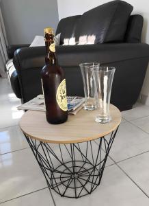 a table with a bottle and two glasses on it at Gîte de Rosemont in Saint-Pol-sur-Ternoise
