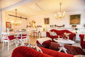 a living room with red couches and a table at Die Kleine Oase Erste Etage in Stuhr
