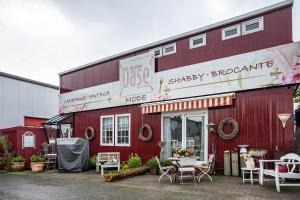 a red building with tables and chairs outside of it at Die Kleine Oase Erste Etage in Stuhr