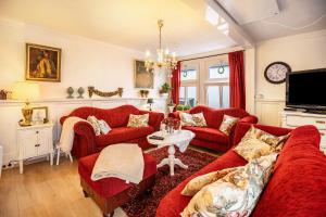 a living room with red couches and a tv at Die Kleine Oase Erste Etage in Stuhr