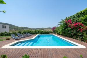 a swimming pool on a deck with chairs and flowers at Bonastre in Bonastre
