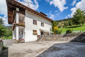 a white house with a fence and a yard at Fichtenhof Wohnung Edelweiss in Tarces