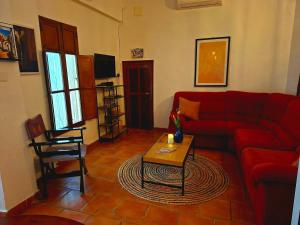 a living room with a red couch and a table at Amarilla in Callosa d'en Sarrià