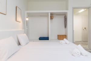 a white bedroom with a large bed with white pillows at A Tinian Room 2 in Tinos
