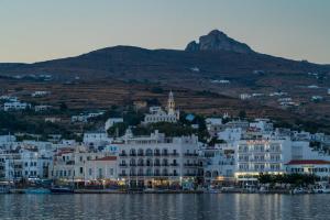 a large white building on the shore of the water at A Tinian Room 2 in Tinos