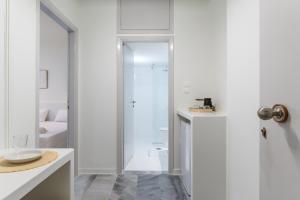 a white bathroom with a shower and a sink at A Tinian Room 2 in Tinos