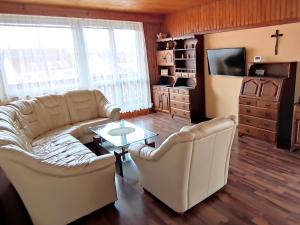 a living room with a couch and a table and a tv at Vila Caba in Křemže