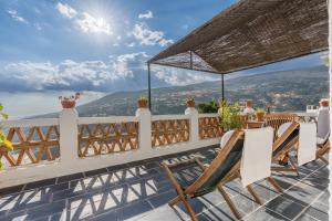 a balcony with chairs and a view of the mountains at Casa Belmonte in Bubión