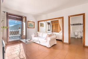 a living room with a white couch and a bedroom at Casa Belmonte in Bubión