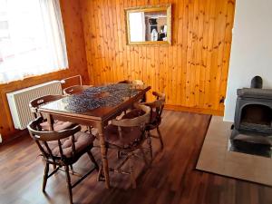 a wooden dining room with a table and a fireplace at Vila Caba in Křemže