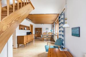 a living room with a staircase and a dining room at Ferienhaus Herich in Nieblum