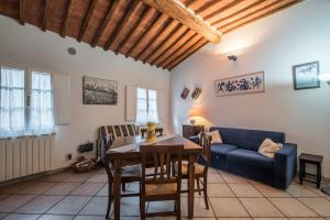 a living room with a table and a blue couch at Il Campo Comfort apt with balcony in Siena