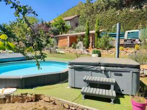 a barbecue with a bench next to a pool at Chambres D'hôtes - Au Soleilo in Mostuéjouls