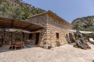 a stone building with a table in front of it at Las Rocas in Fornalutx