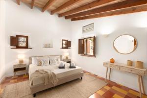a bedroom with a bed and a mirror and a table at Las Rocas in Fornalutx +32 photos