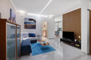 a living room with a couch and a tv at Refúgio Luzia Mar in Santa Luzia