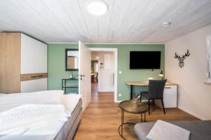 a bedroom with a bed and a table and a tv at Bezauberndes Gästehaus in Zaisertshofen