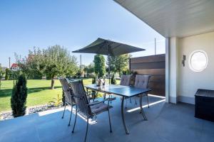 a table and chairs with an umbrella on a patio at Bezauberndes Gästehaus in Zaisertshofen