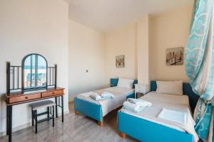 a room with two beds and a desk and a mirror at Blue Pearl Apolakkia in Apolakkiá +37 photos