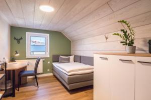a room with a couch and a table and a desk at Bezauberndes Gästehaus in Zaisertshofen