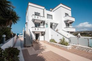 a white building with stairs leading up to it at Blue Pearl Apolakkia in Apolakkiá