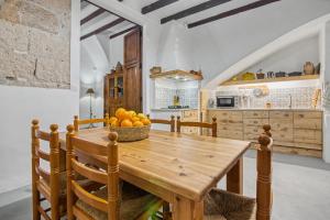 a kitchen with a wooden table and a bowl of oranges at La casa de la Sariera in Jávea