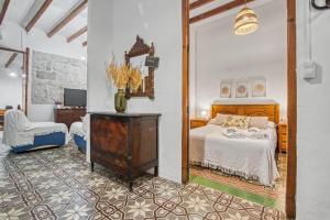 a bedroom with a bed and a chair at La casa de la Sariera in Jávea