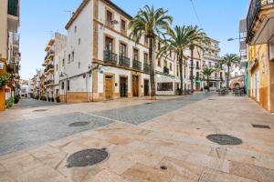 an empty street in a city with palm trees and buildings at La casa de la Sariera in Jávea