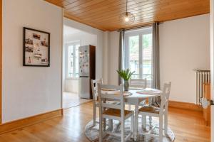 a dining room with a white table and chairs at Appartement Le 47 in Thann