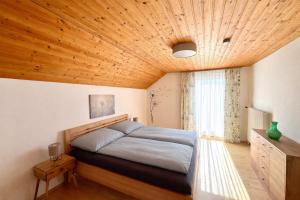 a bedroom with a bed and a wooden ceiling at Ferienhaus "Kleine Auszeit" in Tieschen