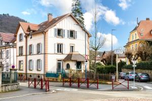 a white house with red gates in front of a street at Appartement Le 47 in Thann
