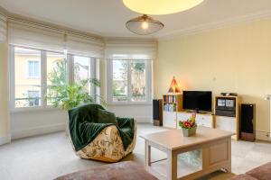 a living room with a chair and a table at Appartement Le 47 in Thann