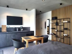 a room with a table and chairs and a kitchen at Apartment Schlossterrassen 8a in Pouch